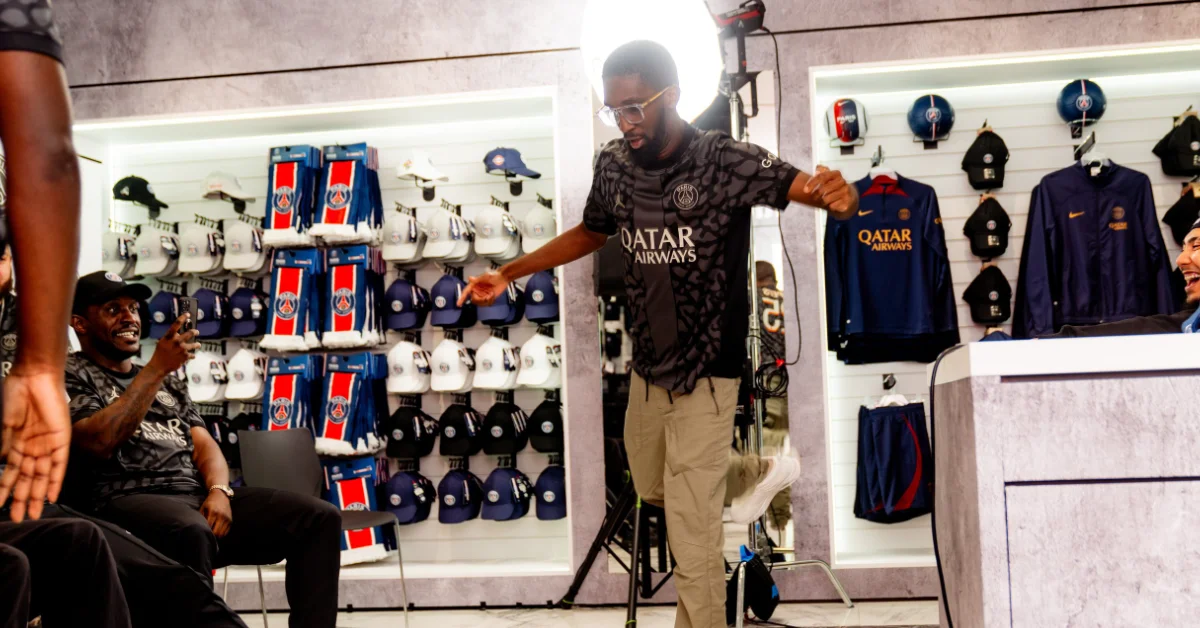 Playmaker Creative Club football clothing photoshoot with branded merchandise displayed in the background.